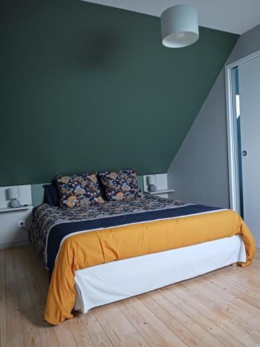 a bed in a bedroom with a blue wall at Gîte de Rosvern in Commana