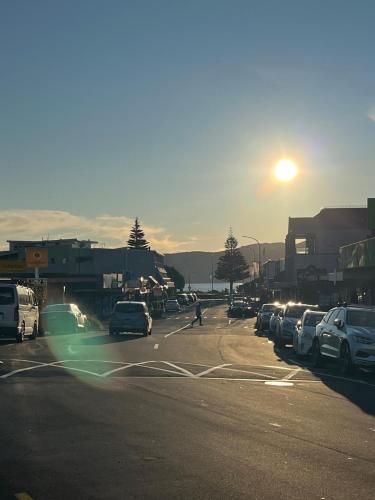 a street with cars parked in a parking lot at Stunning executive family home! in Paraparaumu
