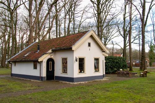 a small white house with a brown roof at De Consistorie in Veenhuizen