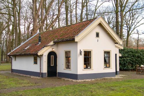 a small white house with a brown roof at De Consistorie in Veenhuizen