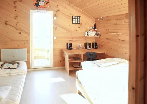 a bedroom with two beds in a wooden cabin at Maison de campagne à Gap avec vue sur la montagne. in La Freissinouse