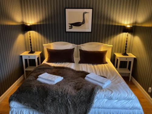 a bedroom with a bed with a blanket and two lamps at Hotell Örnen in Torsby