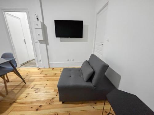 a living room with a couch and a flat screen tv at Confort 6 pers & Wi-Fi rapide in La Courneuve