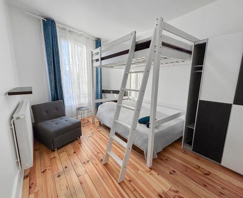 a room with two bunk beds and a chair at Confort 6 pers & Wi-Fi rapide in La Courneuve