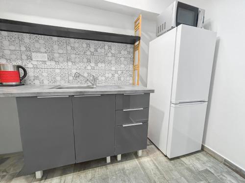 a kitchen with a sink and a refrigerator at Confort 6 pers & Wi-Fi rapide in La Courneuve