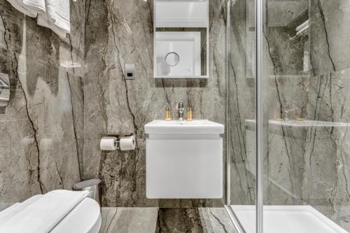 a bathroom with a toilet and a sink and a shower at Cleveland Residences Bloomsbury in London