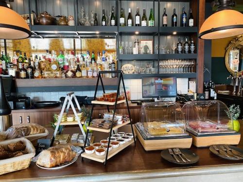 a bakery with a counter with different types of food at Hotel In't Holt 1654 Grand Café & Logement in Zuidhorn