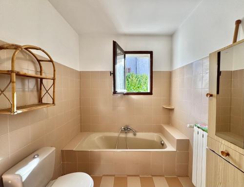 bagno con vasca, servizi igienici e finestra di Villa traditionnelle avec vue imprenable sur les montagnes a Sartène
