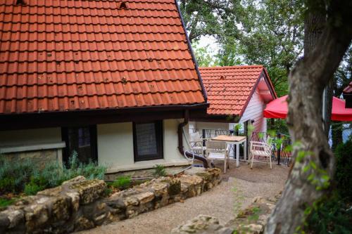a house with a red roof and a table and chairs at Къщички Синьо лято, Черноморец - Варна - Blue Summer Houses Varna in Varna City