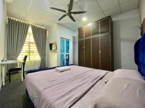 a bedroom with a large bed with a ceiling fan at Mann Maju Inn & Hotel Kuala Berang in Kuala Berang