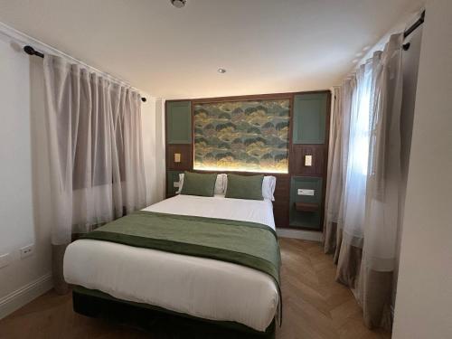 a bedroom with a large bed in a room with windows at BiBo Suites Palacio de Portago in Granada