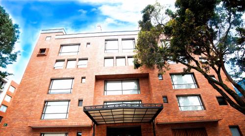 un bâtiment en briques rouges avec un toit triangulaire dans l'établissement Cora 96 Street Apartments, à Bogotá