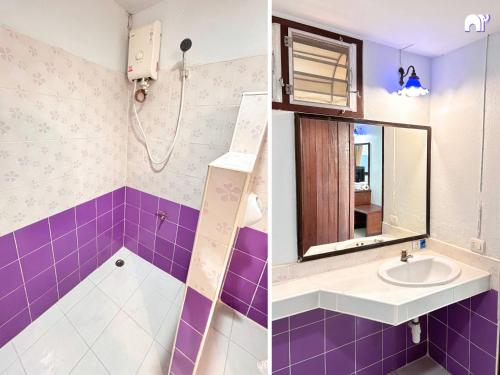 a bathroom with purple tiles and a sink and a mirror at โรงแรมบ้านแก้ว เรือนขวัญ in Si Sa Ket