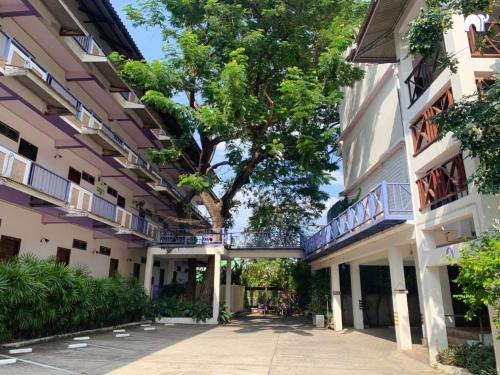 an alley between two buildings with a tree in the middle at โรงแรมบ้านแก้ว เรือนขวัญ in Si Sa Ket