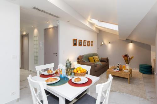 un salon avec une table et des chaises blanches dans l'établissement Le Napoléon, 1min Palais des Festivals, à Cannes