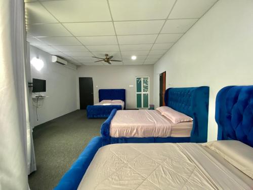 a room with two beds and blue chairs at Mann Maju Inn & Hotel Kuala Berang in Kuala Berang