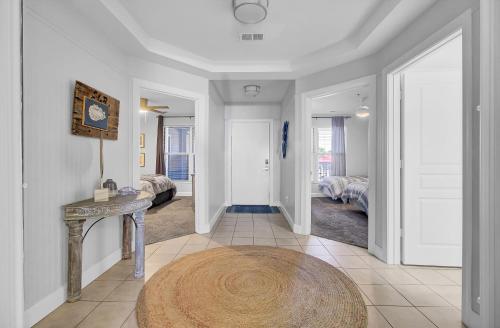 a hallway with a table and a room with beds at Beachfront 3BDR Condo with Pool & Deck Ocean Views Ocean Blvd #102 by AvantStay in Isle of Palms