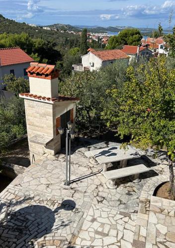 a stone patio with a fireplace in a city at Murter Inn in Murter