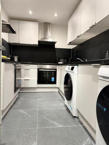 a kitchen with a washer and dryer in it at Private Family and Business Rooms Harrow Fast WiFi in Pinner