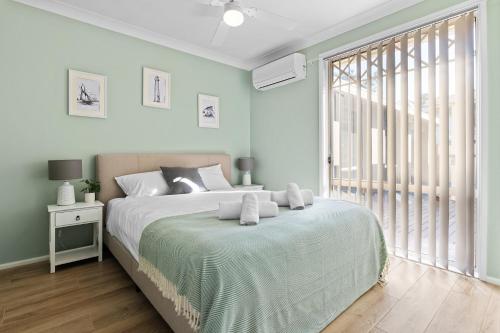 a bedroom with a large bed and a large window at Tranquil Retreat by the Lake with Hot Tub in Chittaway Point