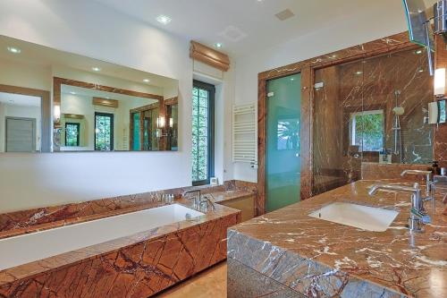 une salle de bain avec deux lavabos et un grand miroir dans l'établissement Villa Les Rostratas, à La Croix-Valmer