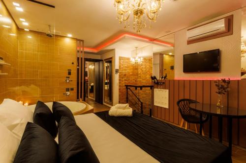 a bedroom with a bed with a tv and a bathroom at Medieval Motel SPA - Porto Alegre-RS in Porto Alegre