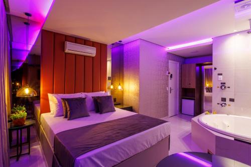 a bedroom with a bed and a tub and a sink at Medieval Motel SPA - Porto Alegre-RS in Porto Alegre