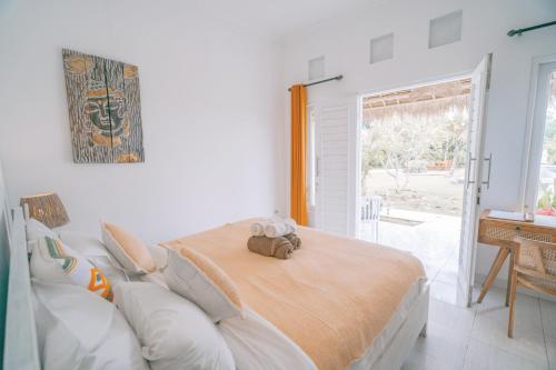 a bedroom with a bed with a teddy bear on it at Sukacita Hill in Uluwatu