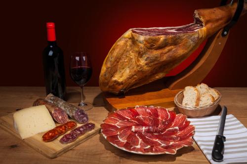 a table with a bottle of wine and meat and cheese at Hotel Noce in Brescia
