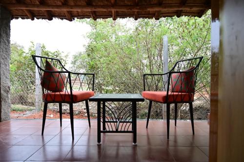 two chairs and a table on a porch at The Hampi Cafe in Hampi