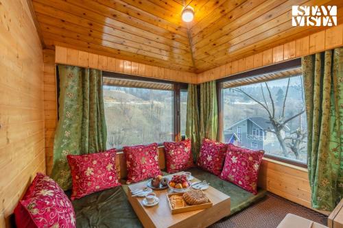 a room with a couch and a table in a room at StayVista at Riverscape with Views, WiFi, Heater in Srinagar
