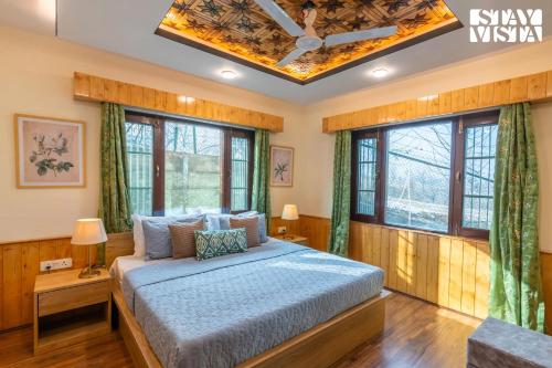 a bedroom with a bed in a room with windows at StayVista at Riverscape with Views, WiFi, Heater in Srinagar