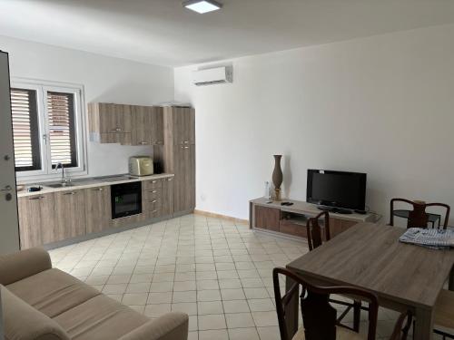 a living room with a table and a kitchen at Triscina 83 in Triscina