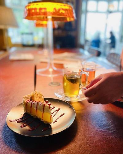 a piece of cake on a plate on a table at Hotel In't Holt 1654 Grand Café & Logement in Zuidhorn