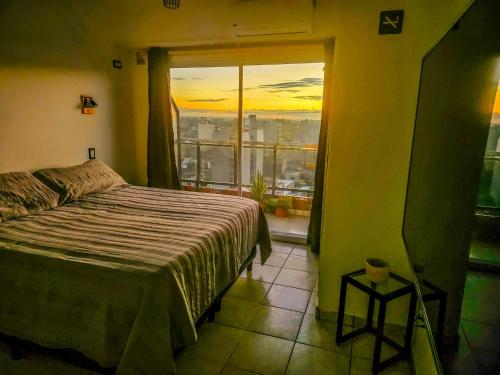 een slaapkamer met een bed en een raam met een zonsondergang bij Monoambiente moderno e inteligente en B Sur Cochera Precio en USD in San Miguel de Tucumán