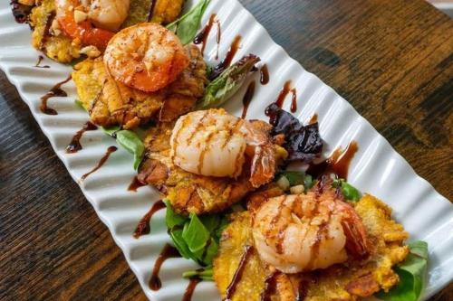 a plate of food with shrimp on a table at Studio Nene by AvantStay Chic Cozy King Bed in Waianae