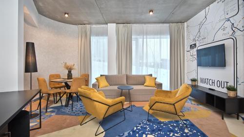a living room with a couch and a table and chairs at Aparthotel Biała Perła - Czarna Góra Resort, Sun & Snow in Sienna