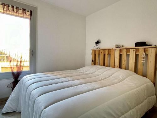 une chambre avec un grand lit blanc avec une fenêtre dans l'établissement Appartement 2 pièces - 4 personnes AR070-025, à Argelès-sur-Mer