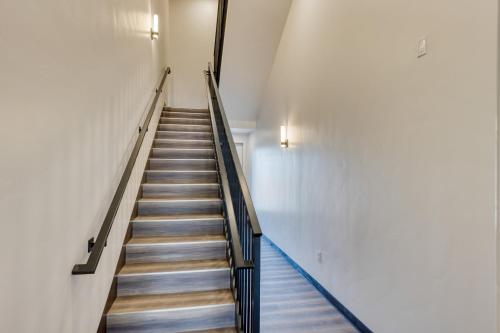 a staircase in a building with wooden floors and white walls at The Aerie Suites by AvantStay Modern Comfort with Mountain Views in Bend