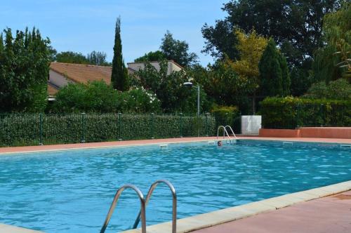 une grande piscine avec de l'eau bleue dans une cour dans l'établissement Maison Studio cabine mezzanine 4 couchages ARGELES SUR MER AR440-126, à Argelès-sur-Mer