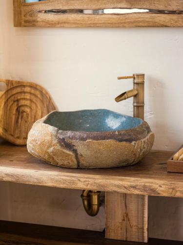 a stone sink sitting on a wooden table at Ailee Villa&Hotel TamCoc in Ninh Binh