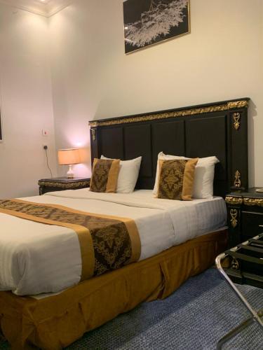 ein Schlafzimmer mit einem großen Bett mit großem Kopfteil in der Unterkunft شقق درة المزهر المخدومة in Riad