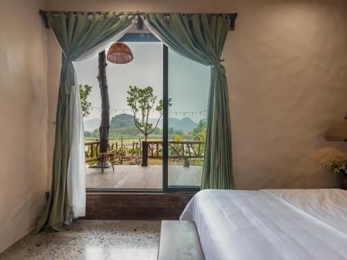 a bedroom with a bed and a large window at Ailee Villa&Hotel TamCoc in Ninh Binh
