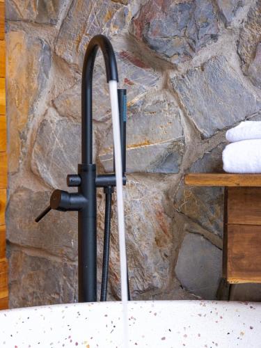 a black and white umbrella standing in front of a stone wall at Ailee Villa&Hotel TamCoc in Ninh Binh