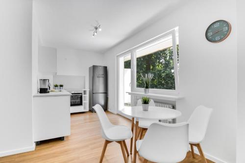 a white kitchen with a table and chairs and a window at Business Apartment mit Balkon und 1 Schlafzimmer in Lippstadt