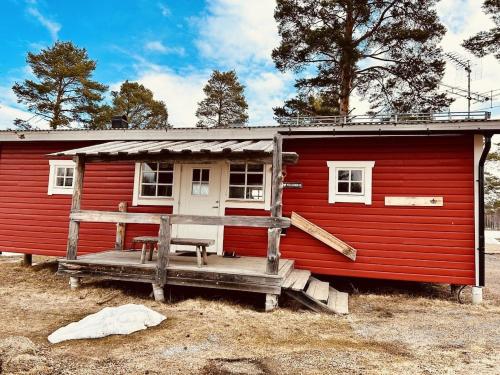 a red cabin with a bench in front of it at 15 Arnljot in Gällö