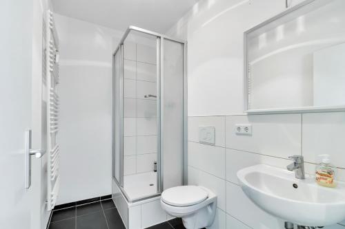 a white bathroom with a toilet and a sink at Business Apartment mit Balkon und 1 Schlafzimmer in Lippstadt