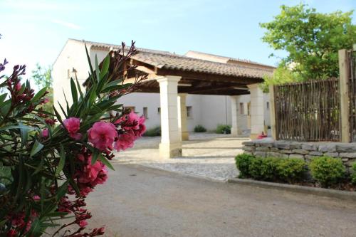 una casa con una recinzione e dei fiori rosa di Maison 4 ou 6 personnes au cœur Corbières a Saint-Laurent-de-la-Cabrerisse