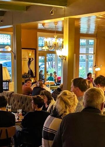a group of people sitting in a restaurant at Hotel In't Holt 1654 Grand Café & Logement in Zuidhorn