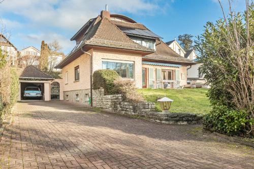 ein Haus mit einer gepflasterten Auffahrt davor in der Unterkunft Green wonder in Friedrichsdorf